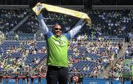 SHA Executive Andrew Lofton holds up Golden Scarf presented by Seattle Sounders FC